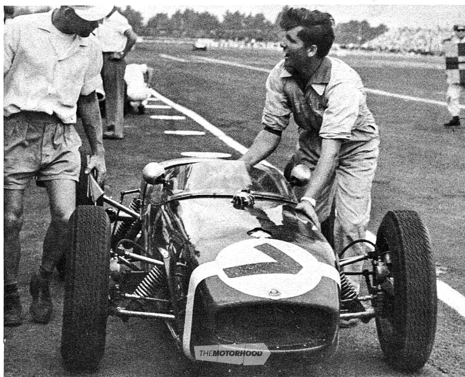 A mechanic pushes the stranded Moss Lotus into the Ardmore pits. Stirling had been leading the 1961 NZGP in the Rob Walker car when the transmission failed