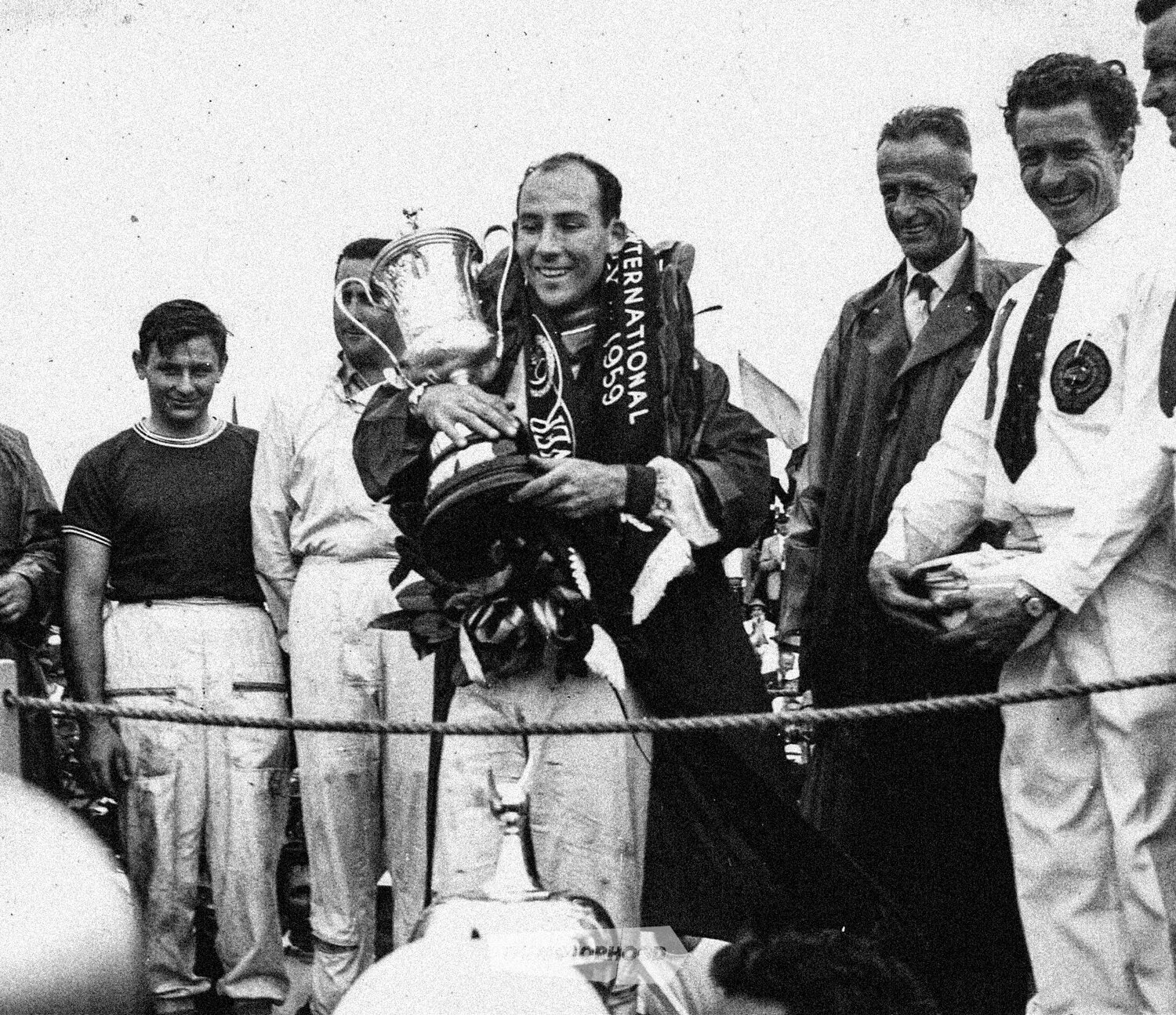 Stirling Moss after winning the 1959 GP at Ardmore in a Cooper Climax, with a young Bruce McLaren and Jack Brabham on his right and a jovial Frank ‘Buzz’ Perkins in white shirt and tie to his left. Perkins was secretary of the New Zealand Grand Prix…